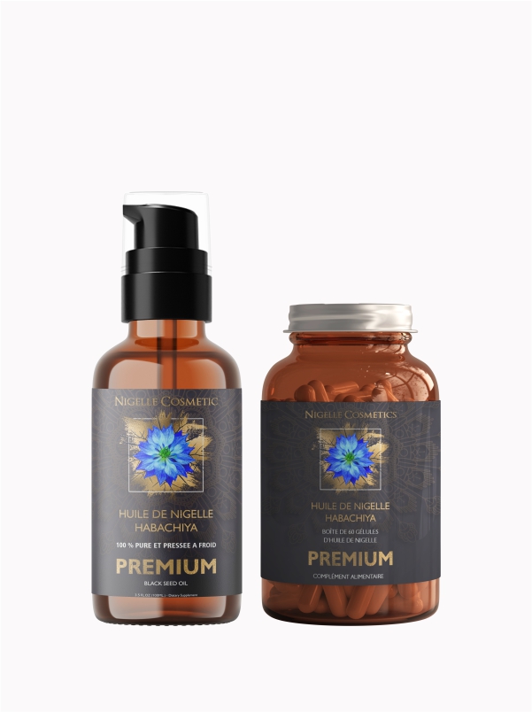 Bottle of black cumin oil next to a bottle of capsules on a white background.